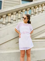 Vestido corto blanco de gasa transparente con cuello redondo y mangas cortas.