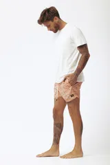 Short de baño salmón con estampado de tablas de surf, cordón ajustable en la cintura y etiqueta lateral de la marca.