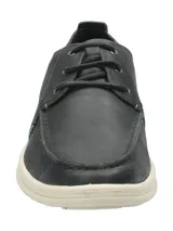Zapato casual tipo náutico de cuero color azul marino, con cordones y suela de goma en color crema. Presenta costuras reforzadas en la puntera y logo de la marca grabado en el lateral.