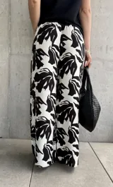 Pantalón palazzo de tiro alto con estampado floral abstracto en blanco y negro, con cintura elastizada y cordón ajustable.