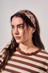 Bandana color marrón con estampado de estilo paisley y motivos florales en color blanco.