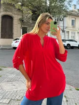 Blusa roja de viscosa y lycra, de corte amplio y largo, con escote en V y mangas 3/4 regulables con trabilla y botón.
