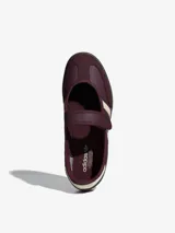 Zapatillas Adidas modelo Samba Jane, color bordó con detalles en blanco. Presentan un diseño tipo Mary Jane con cierre de velcro en el empeine, manteniendo la estética clásica de las Samba con las tres tiras laterales y suela de goma.