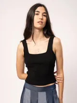 Top tejido negro con escote cuadrado y tirantes anchos.