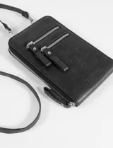 Porta celular de cuero sintético color marrón, con diseño rectangular, cierre principal y dos bolsillos frontales con cierre. Incluye correa larga regulable y extraíble, y cuenta con el logo de la marca grabado en la parte inferior.