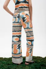 Jean de mezclilla azul oscuro con costuras contrastantes marcadas en el frente y dobladillo ancho vuelto en el ruedo.