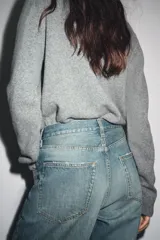 Chaqueta de tejido de punto color verde musgo, de corte cropped, con cuello redondo y cierre frontal de botones oscuros.