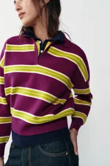 Jersey de punto con diseño de rayas horizontales en colores violeta y verde lima, cuello polo con escote en pico y manga larga con puños ajustados.