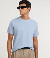 Remera de punto piqué color celeste con efecto melange, cuello redondo y manga corta.
