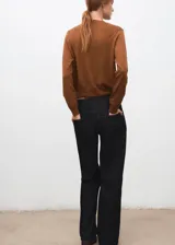 Cardigan de punto fino color tostado, con cuello redondo, manga larga y cierre frontal de botones.