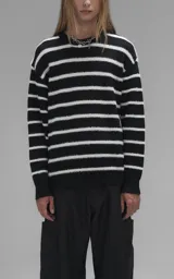 Sweater de cuello redondo con diseño de rayas horizontales en blanco y negro. Confeccionado en tejido de punto con textura suave, corte oversize y terminaciones en punto rib en cuello, puños y ruedo.