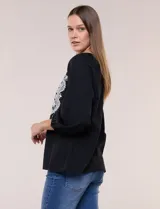 Blusa negra de silueta suelta con escote en V y elegante bordado frontal de arabescos en color blanco. Presenta mangas tres cuartos abullonadas con puños elastizados y diseño de inspiración boho.