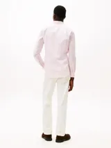 Camisa de vestir color rosa claro, manga larga con puños doblados, cuello con botones y corte slim. Presenta un pequeño logo bordado en el pecho.