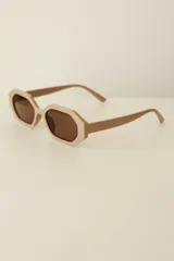 Lentes de sol con armazón de policarbonato en color beige y diseño hexagonal, con cristales oscuros con protección UV400.