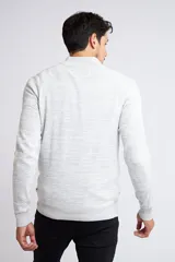 Buzo gris jaspeado de tejido de punto, con medio cierre frontal, cuello alto, manga larga y logo en goma. Corte regular.