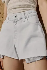 Shorts de jean tiro medio, corte mom fit, con bajo deshilachado y forro de bolsillos delanteros estampado a cuadros que asoma por debajo.
