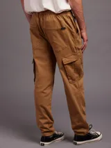 Pantalon tipo jogger cargo color marron, con cintura elastizada con cordon de ajuste, bolsillos laterales con solapa y puños elastizados en los tobillos.