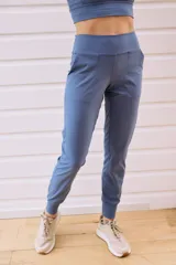 Pantalón tipo babucha de tiro alto, con cintura elástica ancha, bolsillos laterales y puños ajustados en los tobillos.