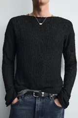 Jersey negro de corte relaxed fit, con estructura de tejido abierto, cuello redondo amplio y manga larga.