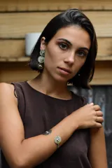 Caravanas colgantes artesanales compuestas por tres discos de alpaca de diferentes tamaños con textura radial, decoradas con circonias transparentes en el centro. Cuentan con perno de plata 925.