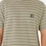 Remera de hombre Rip Curl, de manga corta y corte recto, con cuello redondo negro y estampado a rayas horizontales en tonos beige y marrón. Tiene un bolsillo en el pecho con el logo de la marca.