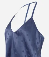 Pijama largo de satén azul con estampa de lunares, compuesto por una musculosa de escote en U con breteles finos y un pantalón de pierna recta con cintura elastizada.