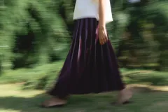 Falda larga color borgoña con finas rayas verticales blancas y cintura elastizada.