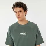Camiseta verde con mangas raglán cortas y estampado con el texto "[NXT-K] NO LIMITS. NO HESITATIONS" en el pecho.