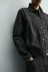 Cazadora de denim de algodón con corte regular fit, cuello solapa, cierre frontal con botones metálicos, mangas largas con puños abotonados y bolsillos laterales de vivo.