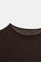 Top de punto fino confeccionado en mezcla de lana y seda, con cuello redondo y manga larga.