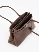 Cartera tipo shopper de cuero vacuno marrón, con silueta estructurada, doble asa de hombro y herrajes metálicos plateados. Incluye tira decorativa con candado y llave colgantes.