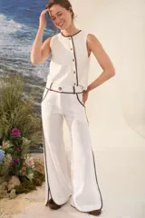Pantalón azul marino de corte wide leg con detalles en tono marrón tostado en la cintura, bolsillos y bordes laterales, cuenta con trabillas para cinturón y cierre frontal.