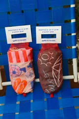 Remera oversize color gris oscuro con estampa frontal en tonos claros que incluye un carrito de helados, una sombrilla y el texto 'Palito Bombón Helado' junto a la firma de la colaboración Pica x Petrichor.