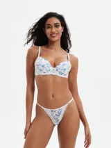 Tanga de encaje blanca con estampado floral en tonos azules y rosados.
