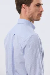 Camisa de manga larga con estampado de cuadros pequeños, cuello abotonado, cierre frontal con botones y un bolsillo en el pecho con detalle bordado.