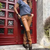 Pantalón de corte recto que combina paneles de cuero color tabaco en el frente y denim azul oscuro en los laterales. Presenta cierre frontal y bolsillos clásicos.