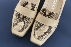 Mocasines de cuero vacuno color beige con textura efecto cocodrilo, punta cuadrada y taco bajo.