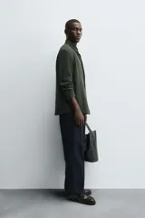 Camisa de corte regular fit confeccionada en tejido de algodón con textura de cuadrillé. Presenta cuello solapa, manga larga con puños abotonados y cierre frontal mediante botonadura.