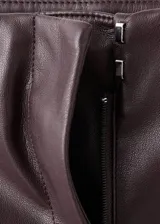 Pantalón largo de tiro bajo en piel sintética color bordó, de diseño ajustado con corte acampanado.