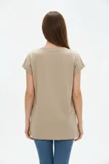 Remera de algodón color beige, de manga corta con vuelta, cuello redondo y corte holgado. Cuenta con un estampado frontal con la inscripción "Manhattan New York East Coast" en tonos celestes.