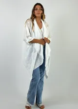 Camisola blanca con bordado calado, mangas 3/4 y corte asimétrico.