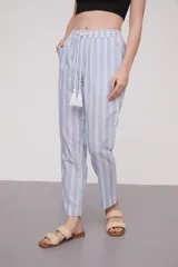 Pantalón babucha celeste con rayas verticales blancas, cintura elástica con cordón y detalle de borlas.