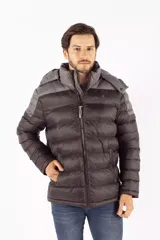 Campera puffer de diseño color block, combinando tonos azul oscuro y gris. Cuenta con capucha desmontable, cierre frontal de cremallera, cuello elevado y bolsillos laterales con cierre de botón.
