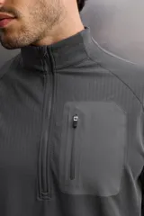 Camiseta de manga larga negra, confeccionada en tejido técnico ligero y elástico. Tiene cuello alto con cremallera, corte slim fit, bolsillo frontal con cremallera y puños con cinta a contraste.