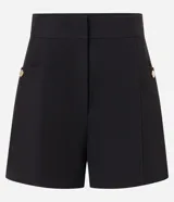 Short sastre de cintura alta con estructura definida, bolsillos laterales decorados con tachuelas metalizadas y recortes delanteros con costura aparente.