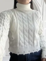 Sweater blanco de tejido de punto trenzado con cuello alto y terminaciones desflecadas.