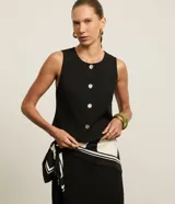 Chaleco de sastrería negro de corte slim, con cuello redondo y cierre frontal de botones metalizados con relieve.