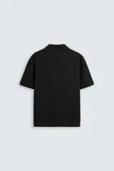 Polo de manga corta color verde oliva, con cuello solapa y abertura frontal tipo polo. Presenta una textura acanalada vertical y un calce regular.