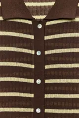 Top de punto confeccionado en mezcla de viscosa, con diseño a rayas horizontales en color marrón y amarillo claro. Presenta cuello polo, manga corta, bajo recto y cierre frontal con botones.