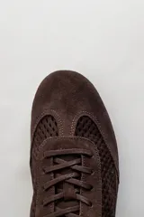 Championes de gamuza color tostado con diseño de paneles perforados en los laterales y empeine. Presentan cierre con cordones al tono y tirador en el talón.